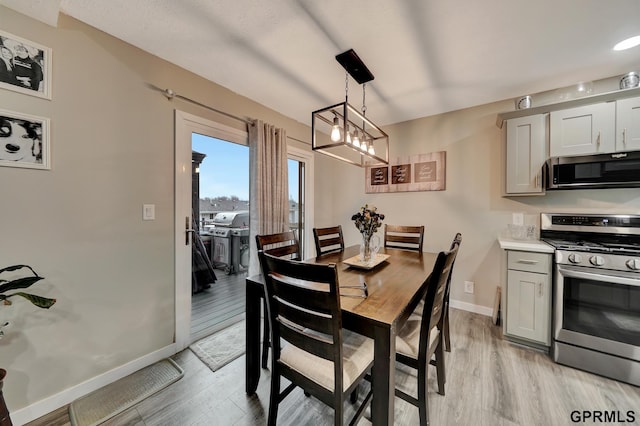 dining room featuring baseboards and light wood finished floors