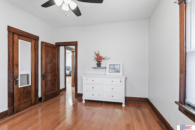 unfurnished bedroom featuring ceiling fan, baseboards, and wood finished floors