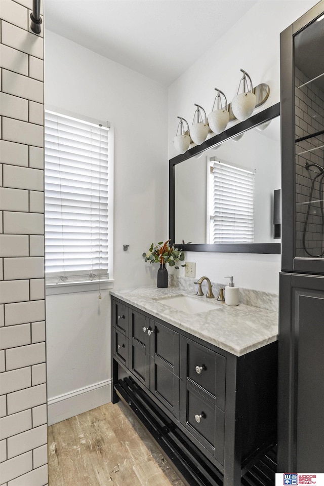 bathroom with vanity, wood finished floors, and baseboards