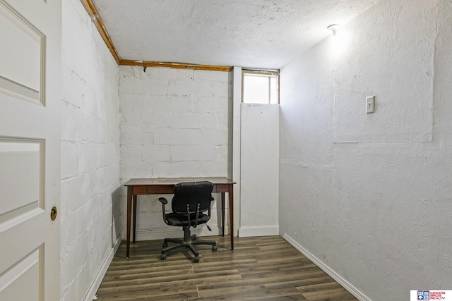 office featuring a textured ceiling, dark wood-style floors, concrete block wall, and a textured wall