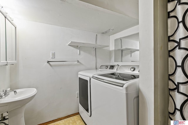 laundry area with a sink, baseboards, and washing machine and clothes dryer