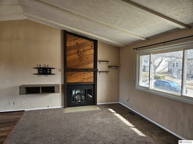 unfurnished living room featuring lofted ceiling, a fireplace with flush hearth, carpet floors, and a textured ceiling