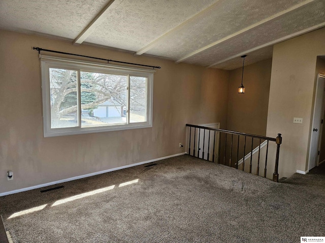 carpeted empty room featuring visible vents, baseboards, and a textured ceiling