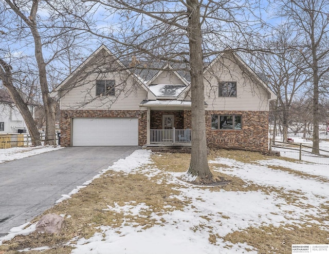 traditional home with a garage, a porch, and driveway