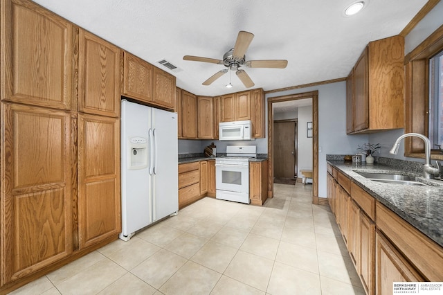 kitchen with white appliances, visible vents, ceiling fan, a sink, and brown cabinets