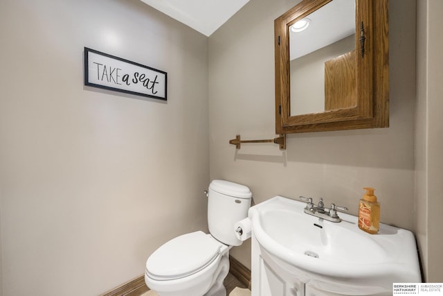 half bathroom with vanity and toilet