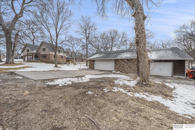 view of snowy exterior with a garage