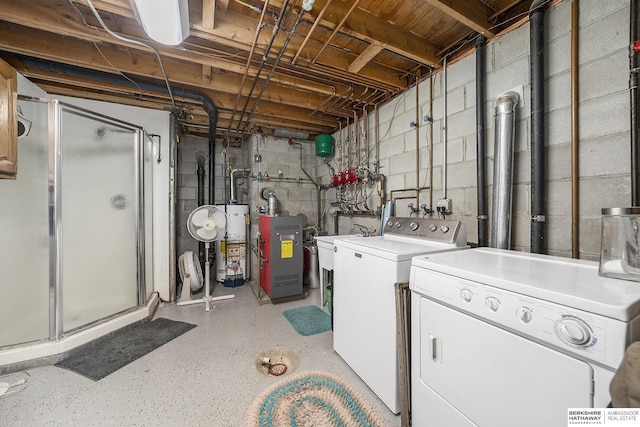 clothes washing area featuring washer and dryer, laundry area, gas water heater, and a heating unit