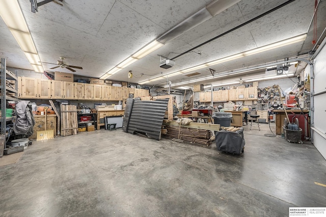 garage with a workshop area, a garage door opener, and a ceiling fan