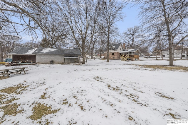 yard layered in snow with a wooden deck