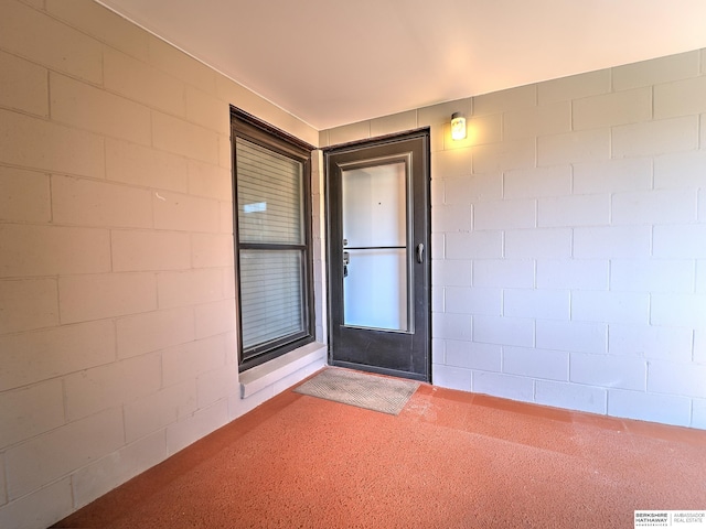 view of exterior entry featuring concrete block siding