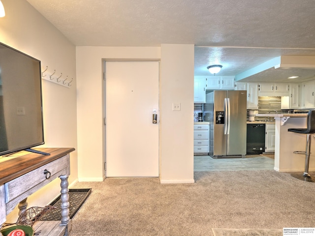 living room with light colored carpet, a textured ceiling, and baseboards