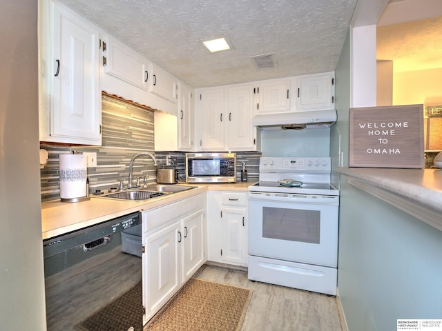 kitchen featuring stainless steel microwave, under cabinet range hood, black dishwasher, white range with electric stovetop, and a sink