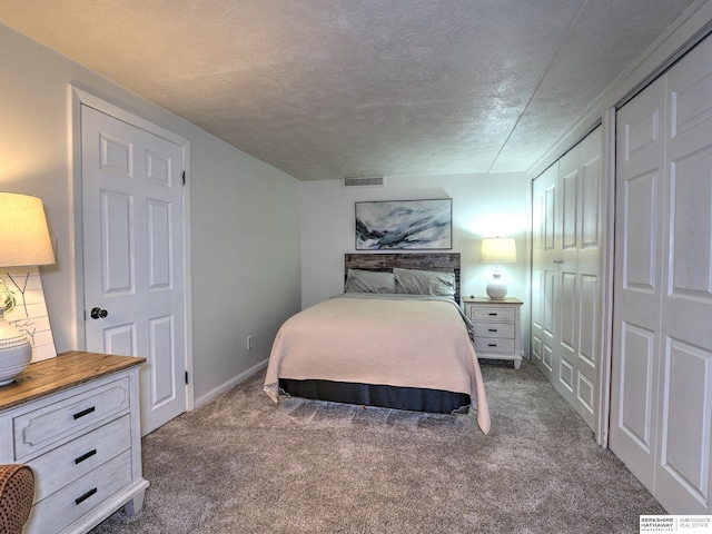 bedroom featuring visible vents, baseboards, a textured ceiling, and dark carpet