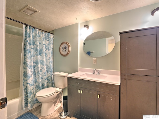 bathroom with visible vents, toilet, a textured ceiling, wood finished floors, and vanity