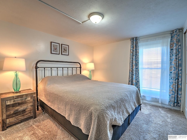 bedroom featuring a textured ceiling and carpet floors