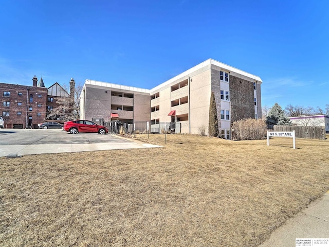 view of building exterior with uncovered parking