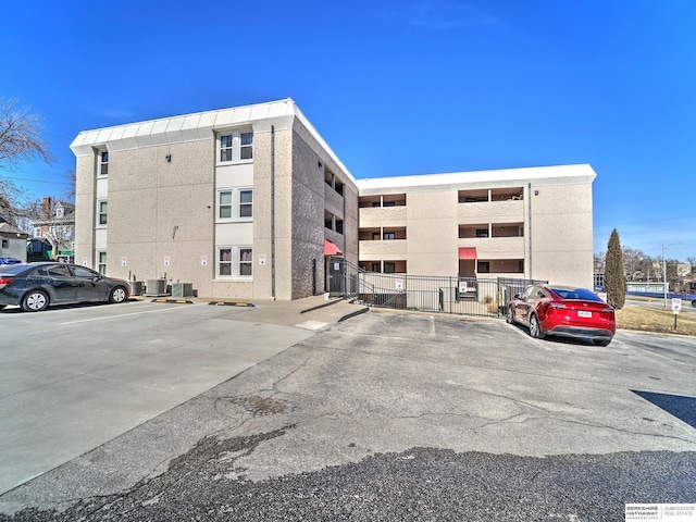 view of property featuring cooling unit and uncovered parking