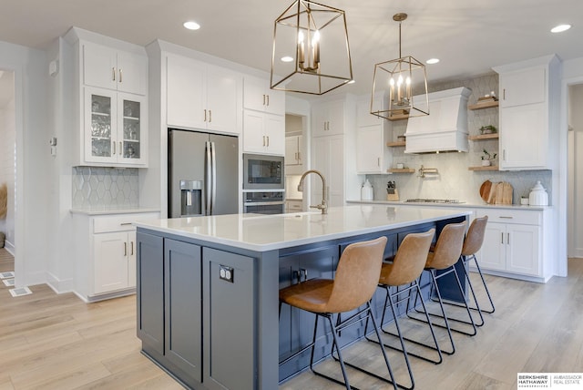 kitchen with appliances with stainless steel finishes, white cabinetry, light countertops, and open shelves