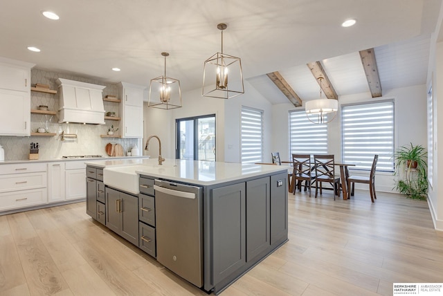 kitchen with stainless steel dishwasher, light countertops, white cabinets, and open shelves