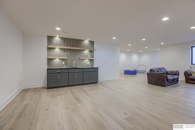 bar featuring a sink, light wood-type flooring, tasteful backsplash, and recessed lighting