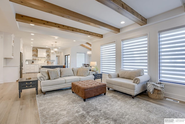 living room featuring visible vents, beamed ceiling, recessed lighting, light wood-style floors, and a chandelier