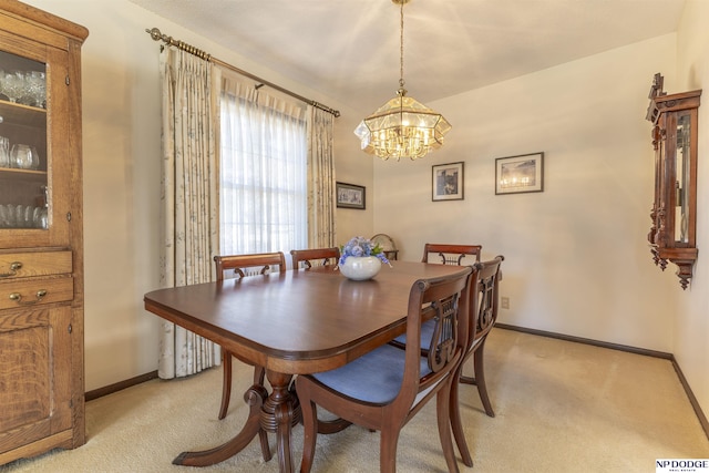 dining space featuring baseboards, light colored carpet, and a chandelier