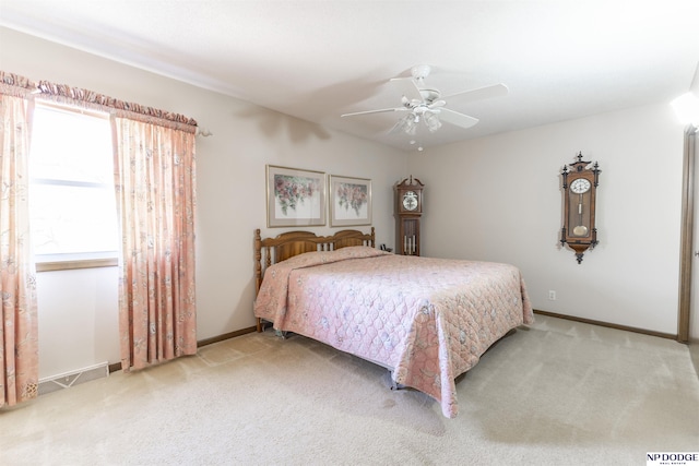 bedroom featuring a ceiling fan, light colored carpet, and baseboards