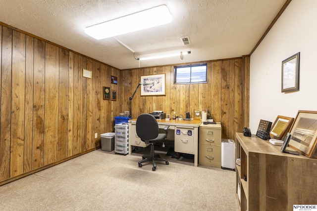 home office with visible vents, carpet, wood walls, and a textured ceiling