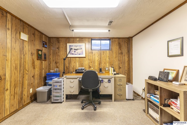 carpeted home office with visible vents, a textured ceiling, and wooden walls