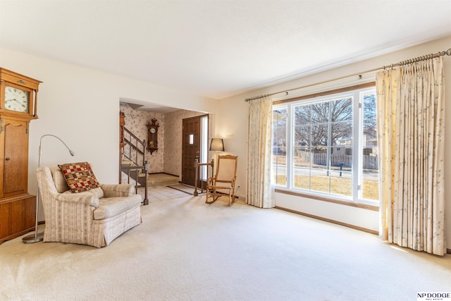 sitting room featuring baseboards, carpet, and stairs