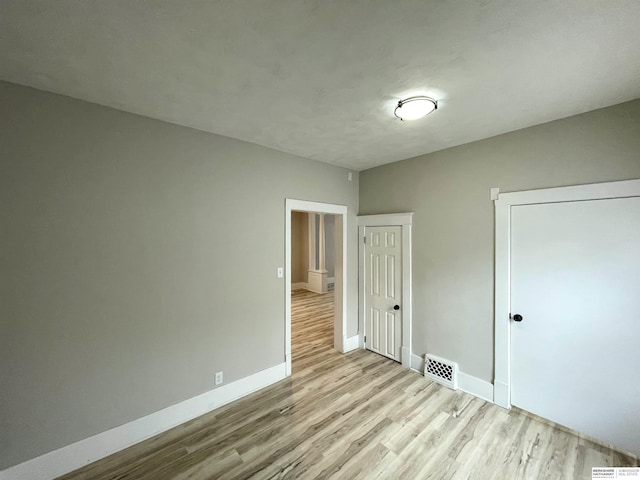 unfurnished bedroom featuring visible vents, light wood-type flooring, and baseboards