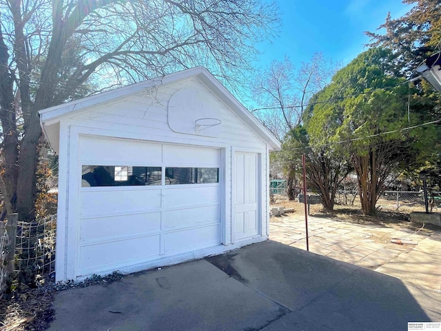 detached garage with driveway and fence