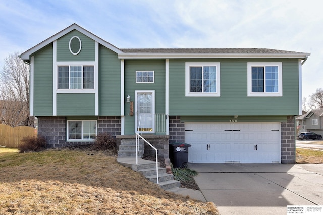 bi-level home with concrete driveway and a garage