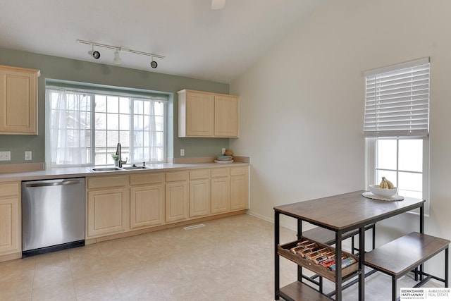 kitchen featuring light brown cabinets, a sink, vaulted ceiling, light countertops, and dishwasher