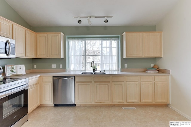 kitchen featuring a sink, visible vents, appliances with stainless steel finishes, and light brown cabinets