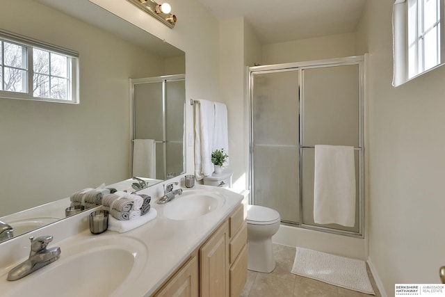 bathroom featuring a shower stall, a healthy amount of sunlight, and a sink