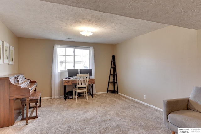 office with a textured ceiling, visible vents, baseboards, and light carpet