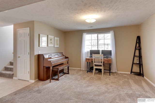 carpeted office featuring visible vents, a textured ceiling, and baseboards