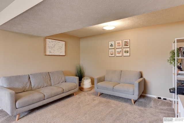 carpeted living room featuring baseboards and a textured ceiling