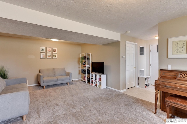 carpeted living area featuring visible vents, baseboards, and a textured ceiling