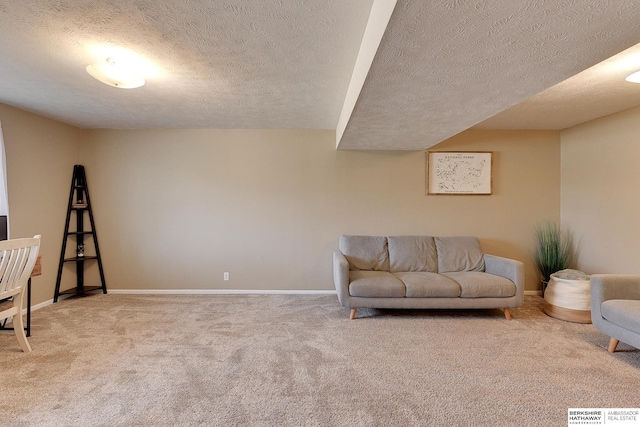 carpeted living area featuring a textured ceiling and baseboards