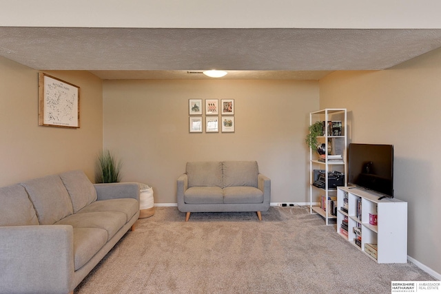 living area featuring baseboards, carpet floors, and a textured ceiling