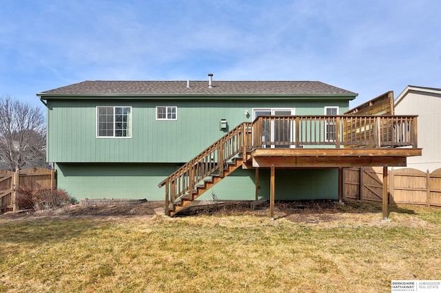 back of property with stairway, fence, roof with shingles, a yard, and a deck