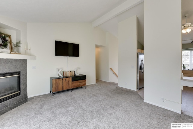 living area featuring baseboards, visible vents, lofted ceiling with beams, a tile fireplace, and carpet flooring