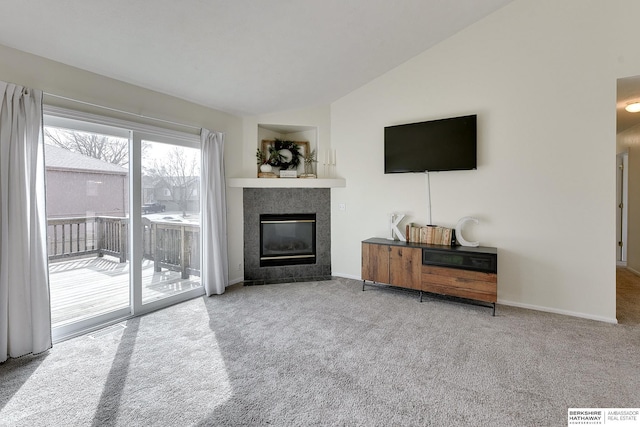 living area featuring a tiled fireplace, baseboards, lofted ceiling, and carpet floors