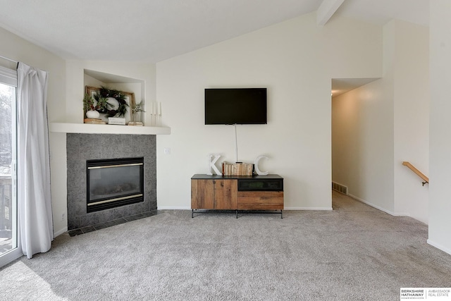 unfurnished living room with lofted ceiling with beams, visible vents, carpet, and a tiled fireplace