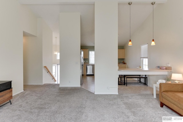 living area with a high ceiling, baseboards, and carpet floors