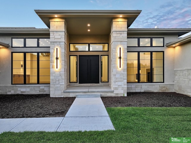 property entrance featuring stone siding and stucco siding