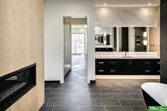 bathroom with recessed lighting, a soaking tub, a fireplace, and vanity